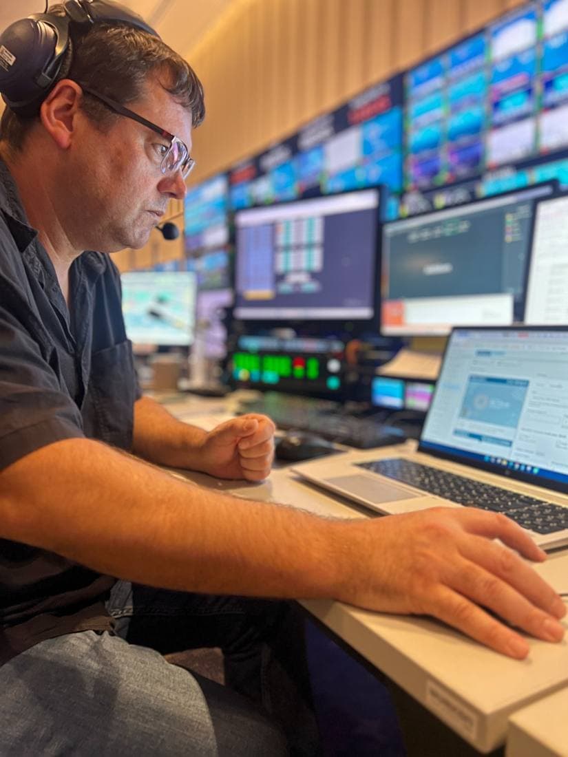 Operator wearing a headset working at a laptop in the control room